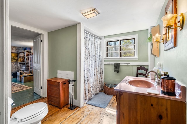 full bath featuring vanity, wood finished floors, toilet, and curtained shower