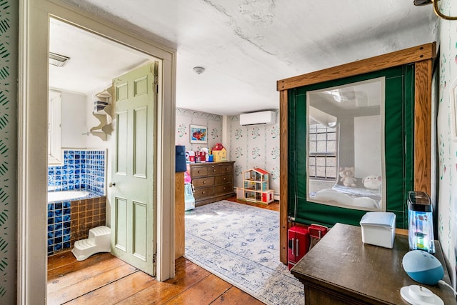 interior space featuring a wall mounted AC and hardwood / wood-style floors