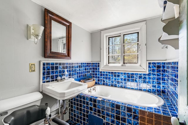 bathroom featuring tile walls, ornamental molding, and a bath
