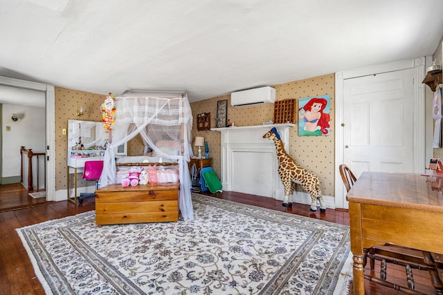 bedroom featuring baseboards, a wall mounted air conditioner, hardwood / wood-style floors, and wallpapered walls