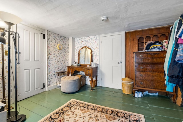 bedroom with wood finished floors and wallpapered walls
