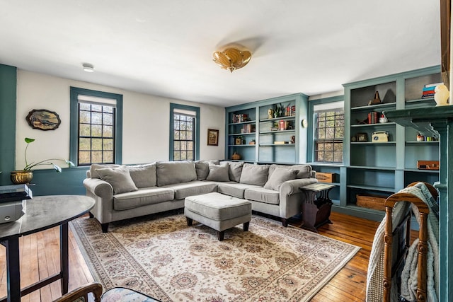 living room featuring built in shelves and hardwood / wood-style floors