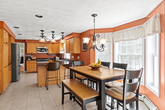 dining room featuring a baseboard radiator, plenty of natural light, and a chandelier