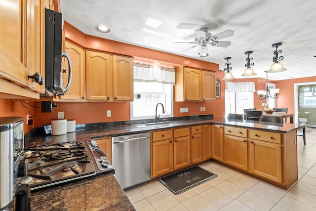 kitchen with stainless steel dishwasher, a peninsula, a sink, ceiling fan with notable chandelier, and light tile patterned floors