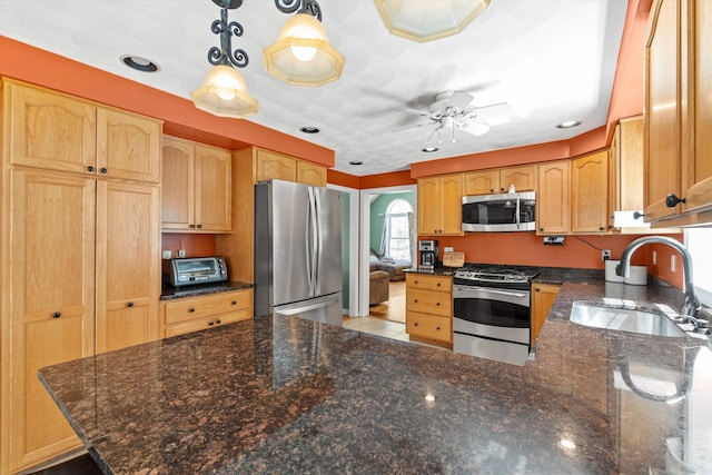 kitchen featuring appliances with stainless steel finishes, a sink, a peninsula, a ceiling fan, and a toaster