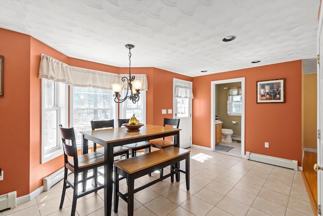 dining room featuring baseboards, a baseboard radiator, light tile patterned flooring, and a notable chandelier