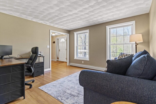 office space with baseboards, wood finished floors, and a baseboard radiator