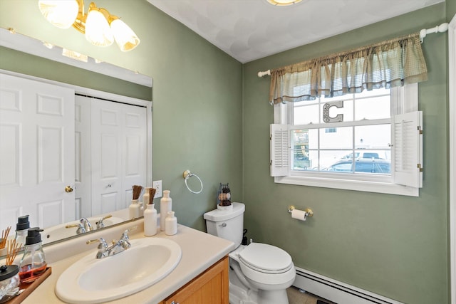 bathroom featuring vanity, a baseboard heating unit, and toilet