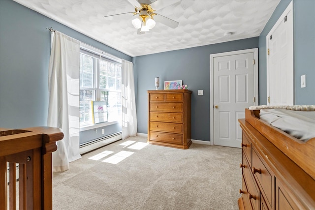 bedroom featuring ceiling fan, baseboards, light colored carpet, and baseboard heating