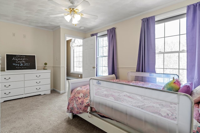 carpeted bedroom with crown molding, ceiling fan, and a baseboard heating unit