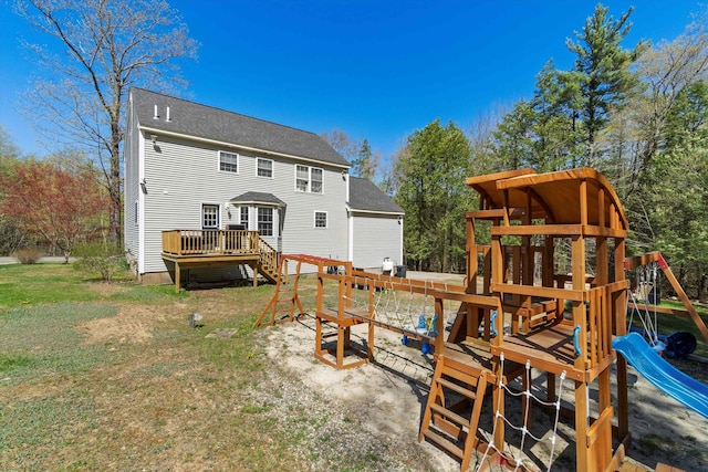 rear view of house featuring a yard, a wooden deck, and a playground