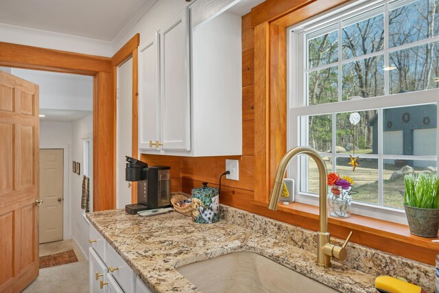kitchen featuring a sink, white cabinetry, and a wealth of natural light