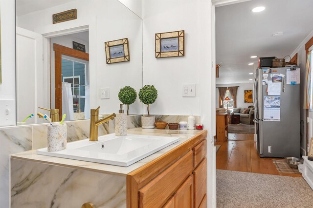bathroom with recessed lighting, wood finished floors, and vanity