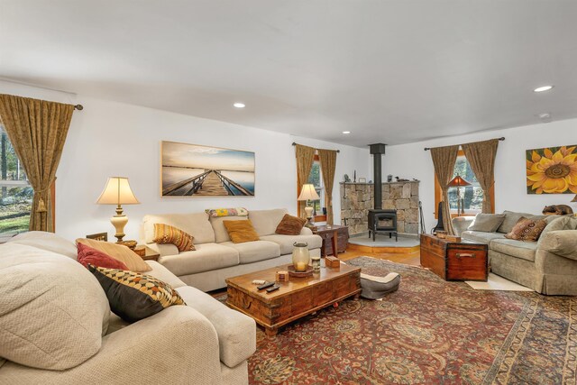 living area with recessed lighting, a wood stove, and wood finished floors