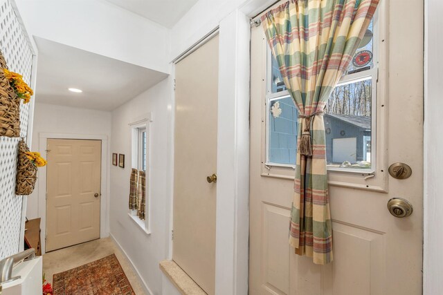 hall featuring recessed lighting and baseboards