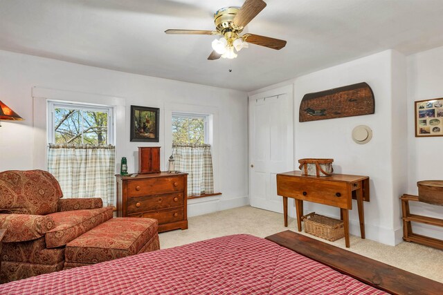 bedroom featuring light colored carpet, baseboards, and multiple windows