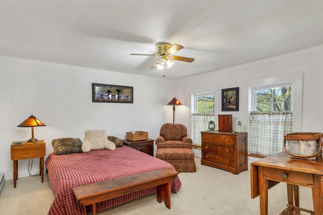 bedroom with a ceiling fan and light carpet