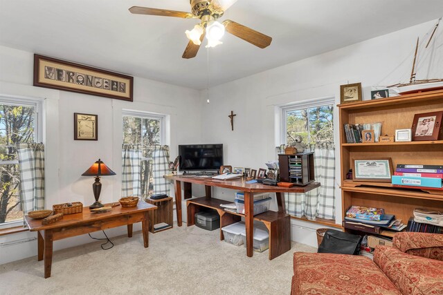carpeted home office with a ceiling fan and a wealth of natural light