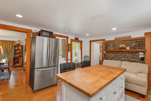 kitchen with white cabinets, light wood finished floors, freestanding refrigerator, recessed lighting, and butcher block counters