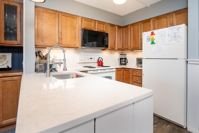 kitchen with a sink, brown cabinets, decorative backsplash, and white appliances