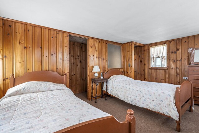 bedroom with wooden walls and carpet