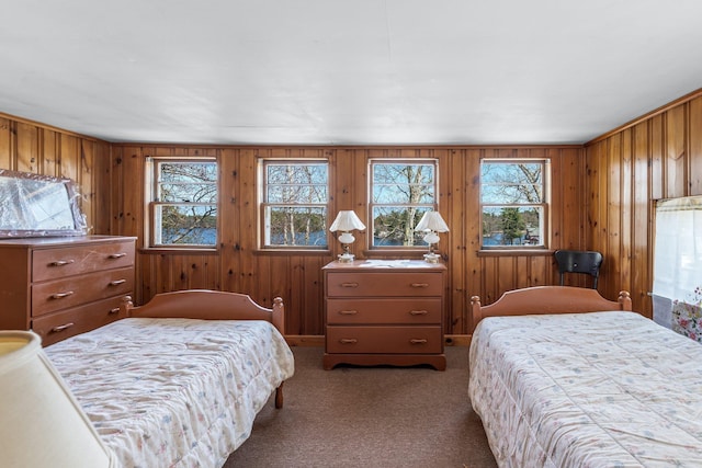 bedroom featuring wooden walls and carpet