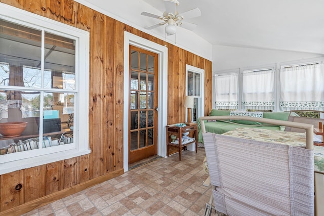 sunroom / solarium with wooden walls, brick patterned floor, and vaulted ceiling