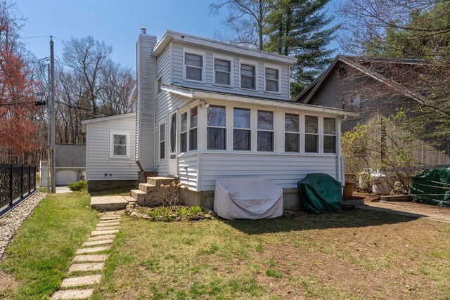 back of house with a lawn, fence, and a chimney