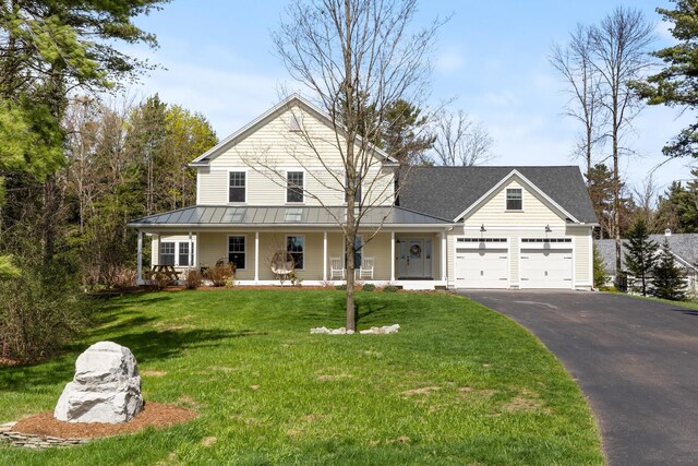 view of front of home with a porch, a standing seam roof, metal roof, aphalt driveway, and an attached garage