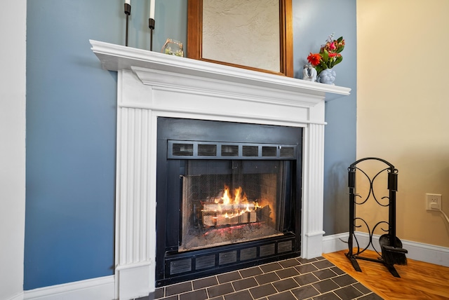 details featuring baseboards and a fireplace with flush hearth