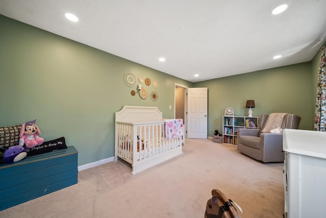 carpeted bedroom with recessed lighting, baseboards, and a nursery area