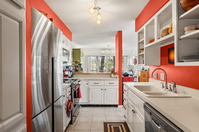 kitchen featuring light countertops, a sink, appliances with stainless steel finishes, light tile patterned floors, and a notable chandelier
