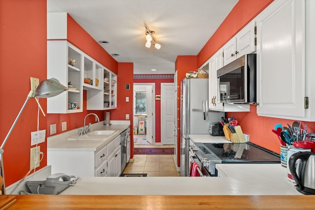 kitchen featuring a sink, light countertops, light tile patterned flooring, stainless steel appliances, and white cabinetry