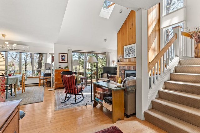 living area with a brick fireplace, high vaulted ceiling, a wall unit AC, and plenty of natural light