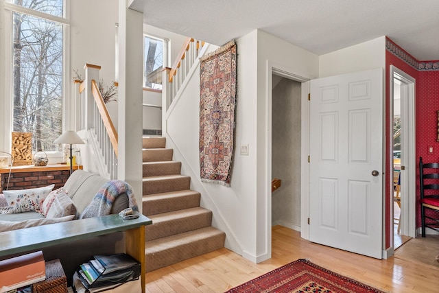 staircase featuring wood-type flooring and baseboards