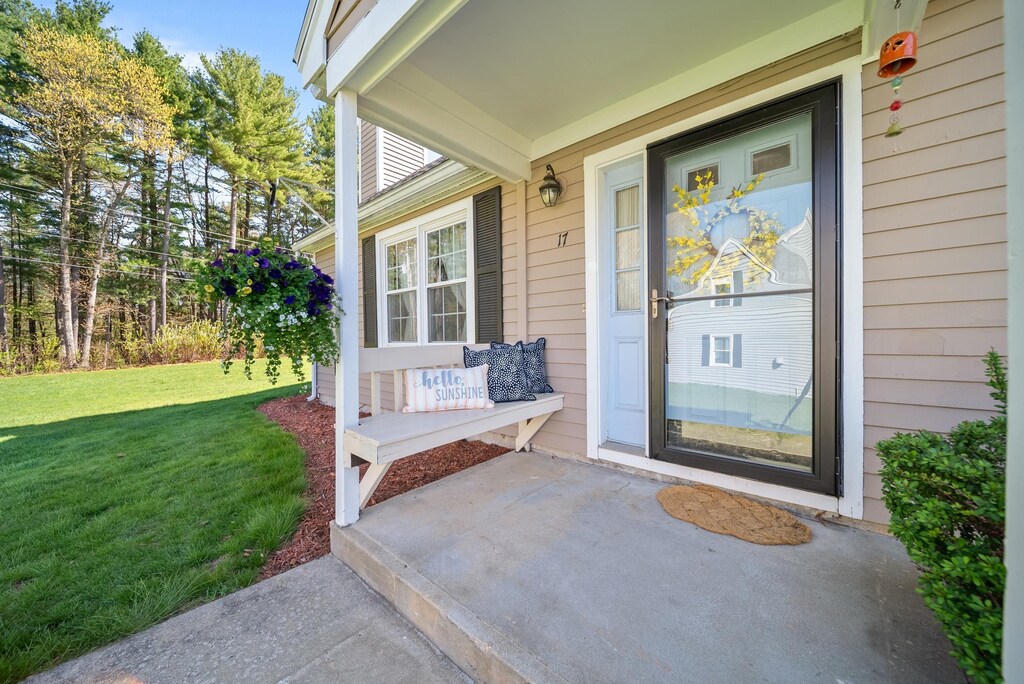 entrance to property featuring a porch and a yard