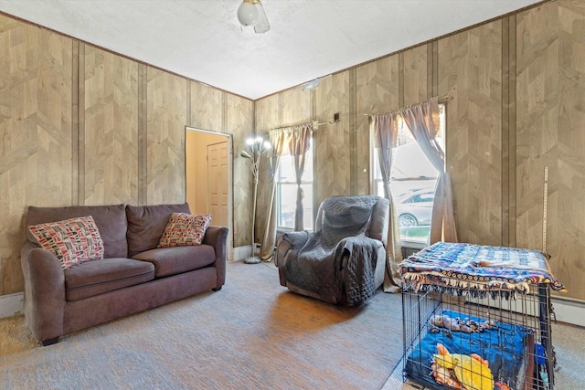 carpeted living area with wood walls