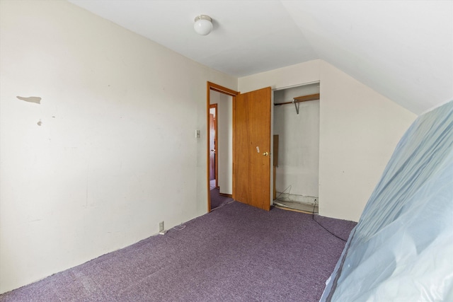 carpeted bedroom featuring lofted ceiling and a closet