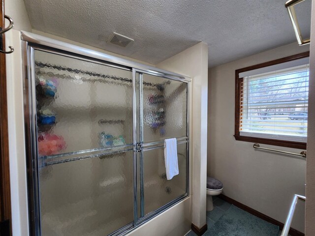 bathroom with toilet, a textured ceiling, visible vents, and tile patterned flooring