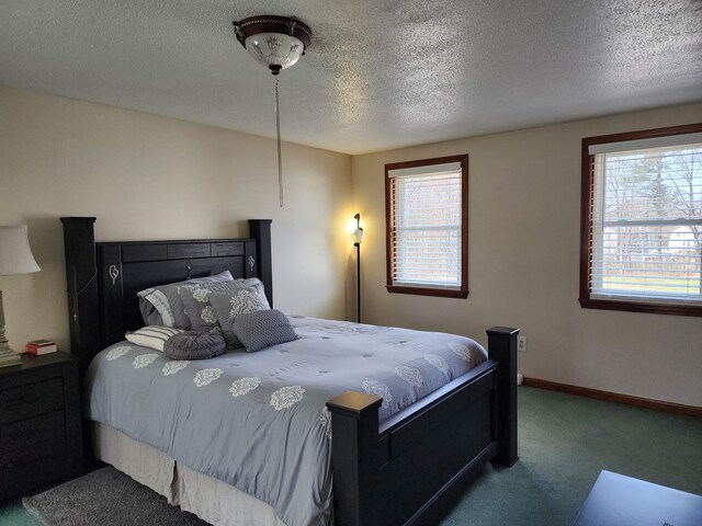 carpeted bedroom featuring a textured ceiling and multiple windows