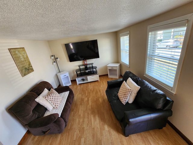 living room with baseboards, a textured ceiling, and wood finished floors