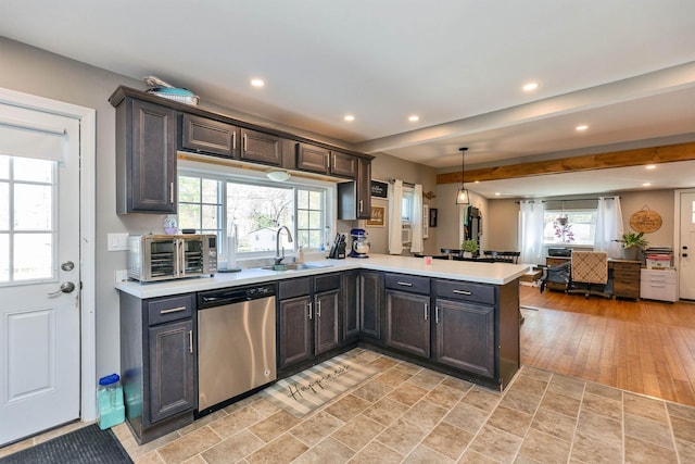 kitchen featuring light countertops, a peninsula, a toaster, and dishwasher