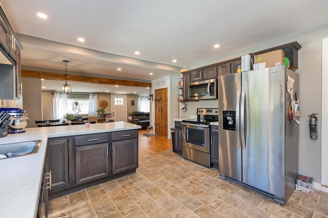 kitchen with recessed lighting, light countertops, appliances with stainless steel finishes, and a peninsula