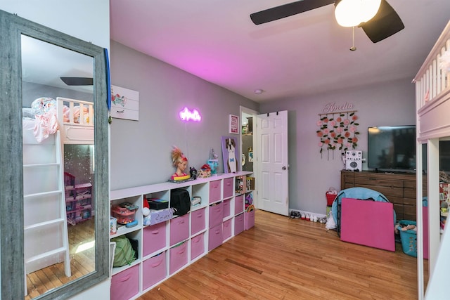 recreation room with a ceiling fan and light wood finished floors