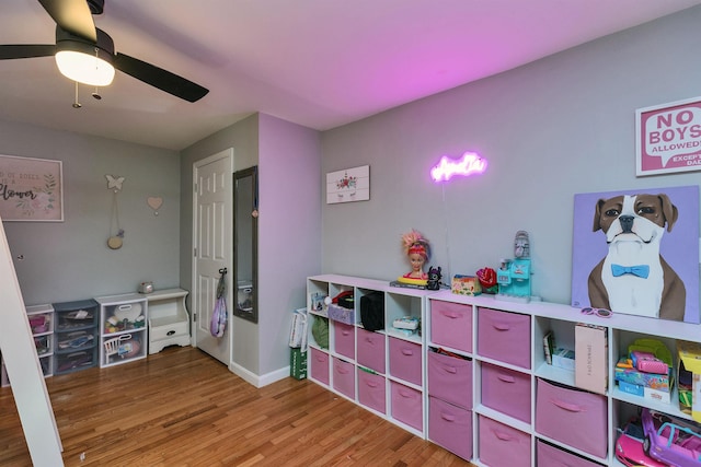 game room with light wood-style floors, baseboards, and a ceiling fan