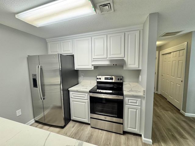 kitchen featuring appliances with stainless steel finishes, under cabinet range hood, light wood-type flooring, and visible vents