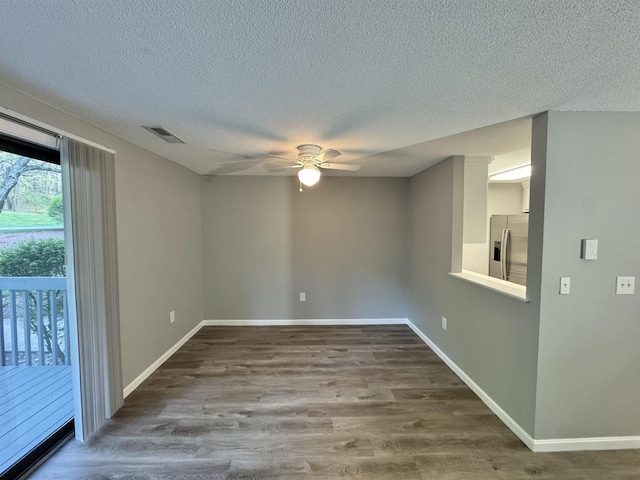 spare room with visible vents, a ceiling fan, a textured ceiling, and wood finished floors