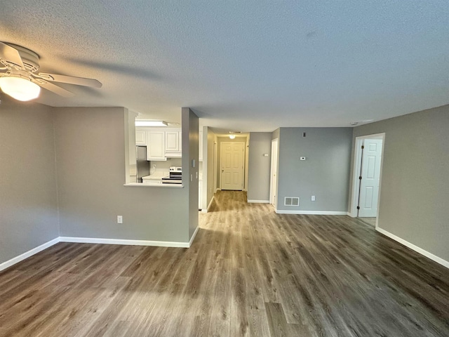 unfurnished living room with a ceiling fan, baseboards, visible vents, and dark wood-type flooring