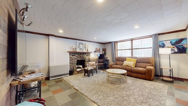 living room with baseboards, ornamental molding, and a stone fireplace