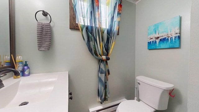bathroom featuring toilet, a sink, and a baseboard radiator